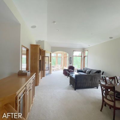 Open-plan living room after painting, cream walls and a vaulted ceiling