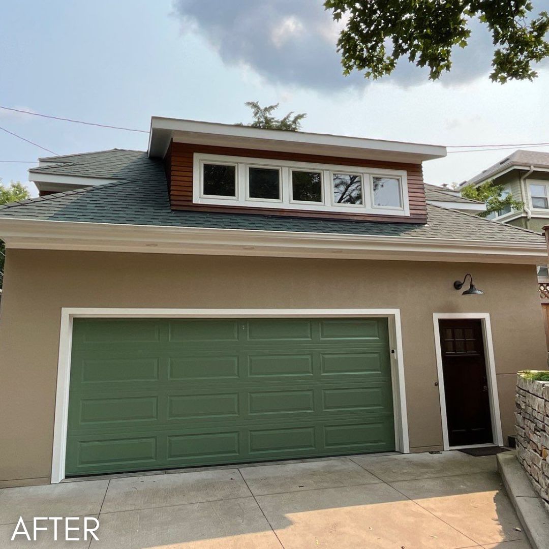 Garage in tan stucco with a sage green door below a cedar-clad dormer