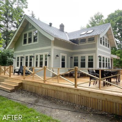 Craftsman house in sage green with a wide cedar deck across the back