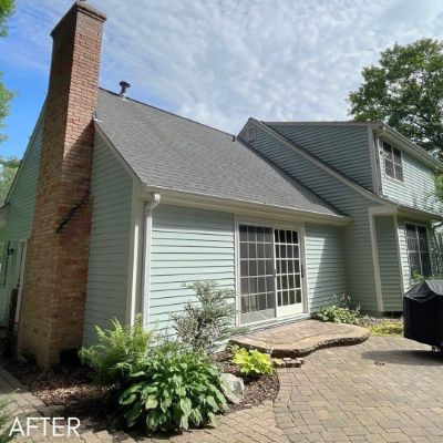 Pale green house with a brick chimney and a paved courtyard