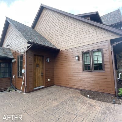 House in tan shingle and stained cedar siding around a wood front door