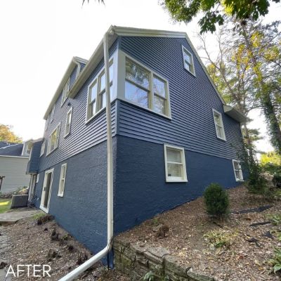 Two-story house in slate blue siding with white window trim