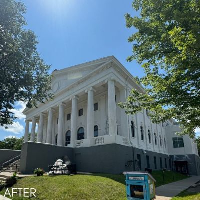 Neoclassical church with white columns above a painted gray base