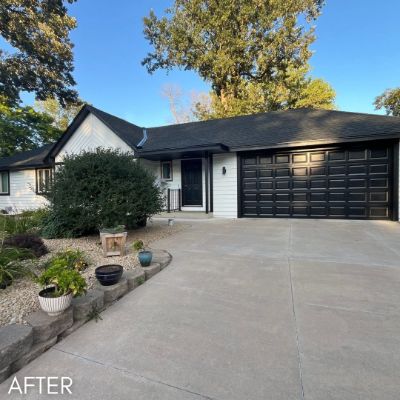 Single-story house in charcoal siding with a black garage door