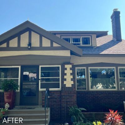 Tudor-style house in cream stucco with dark timbering and brick