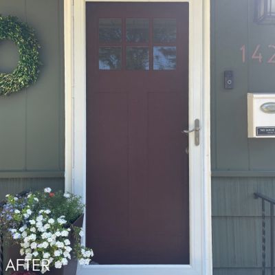 Front door painted deep plum beside pale green siding