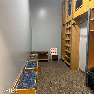 Waiting area after painting, pale gray walls beside wood shelving