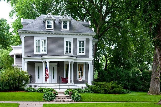 Victorian house painted mauve with white trim and a covered front porch