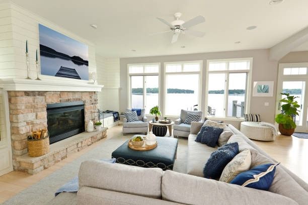 Lakeside living room in white shiplap with a stone fireplace and navy furnishings