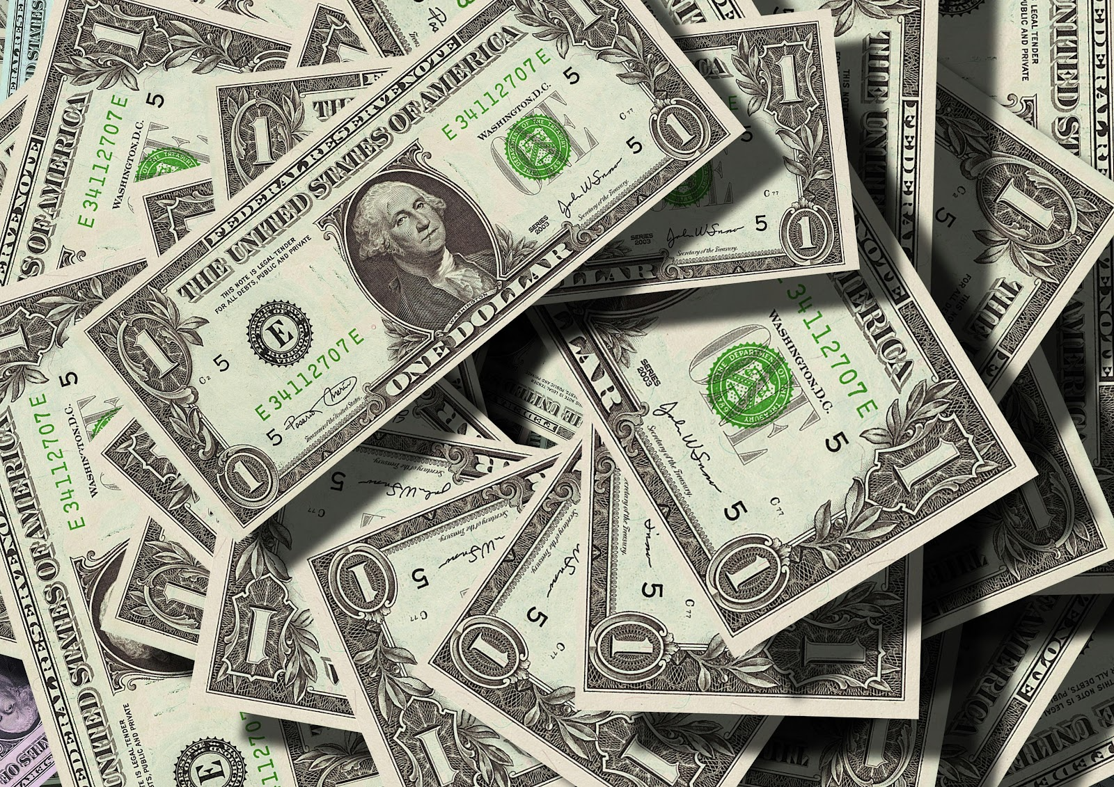 A scattered pile of one dollar bills