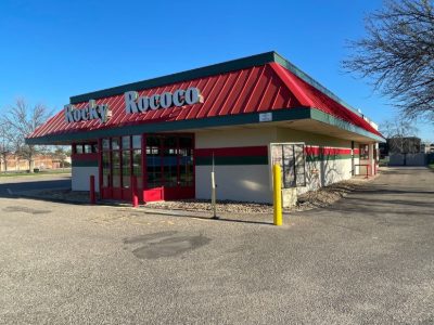 Rocky Rococo restaurant exterior with a red metal roof and green and red trim