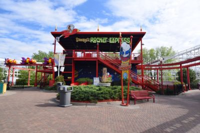 Snoopy's Rocket Express ride station painted bright red under a blue sky